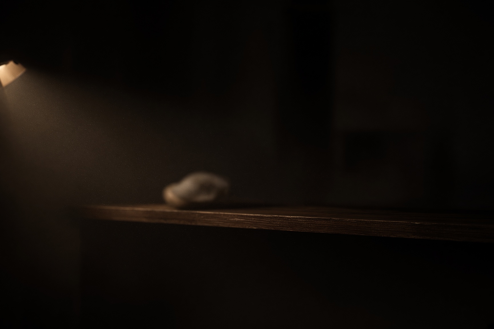 A lamp-lit shelf holding something the lens will not resolve